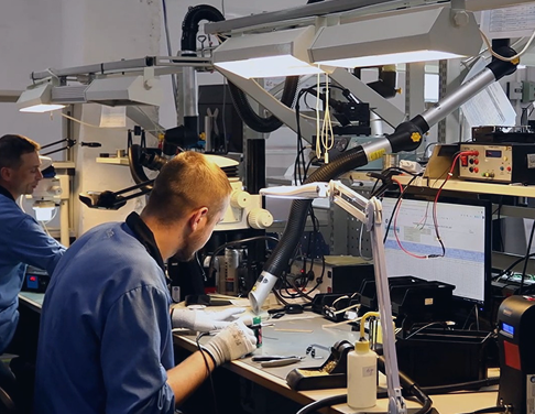 Operator soldering through-hole components on a PCB