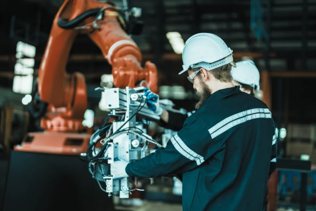 Technician working on an industrial robot cell