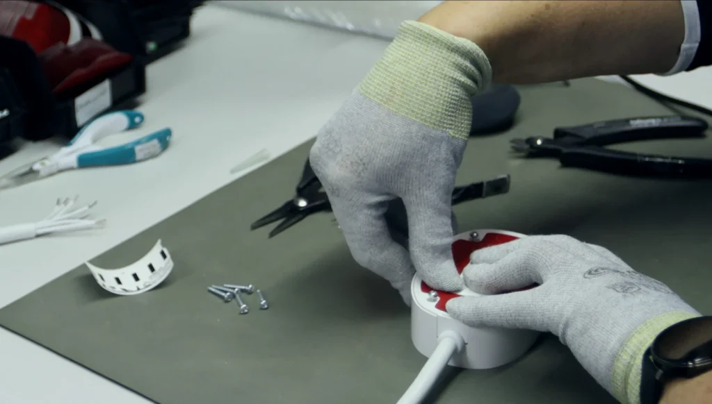 TECHTO technician assembling a unit with cable harness at a box-build workstation